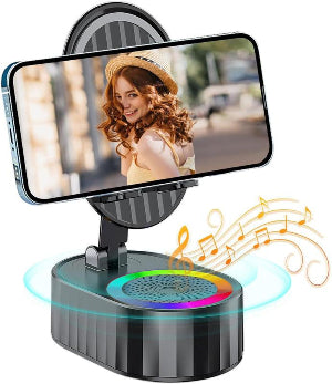 Phone holder with a smartphone displaying a woman's face, placed on a colorful speaker.